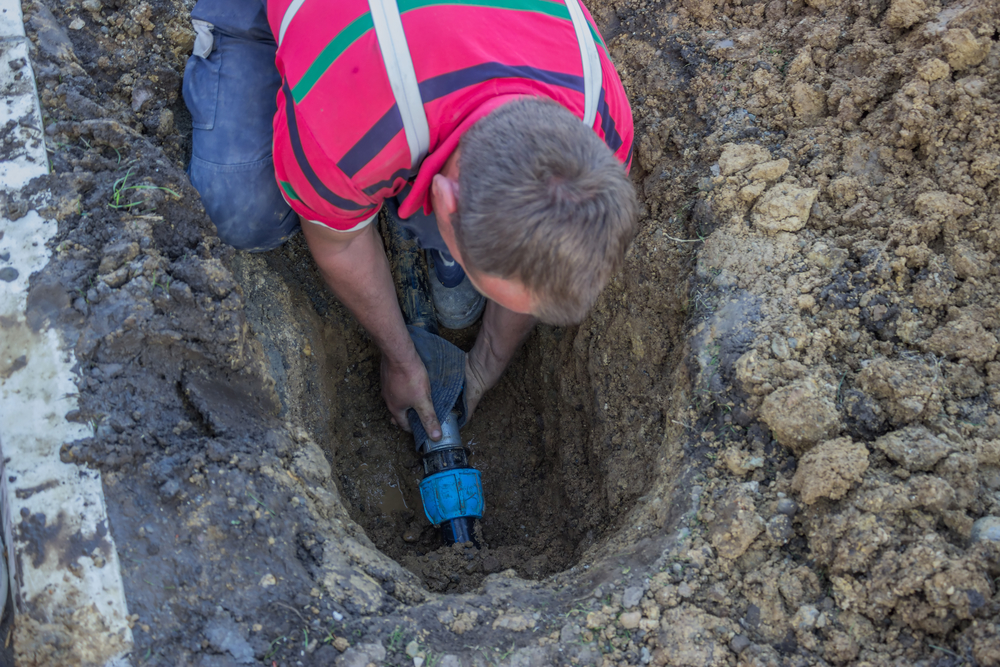 utility worker in trench repair the broken pipe 2