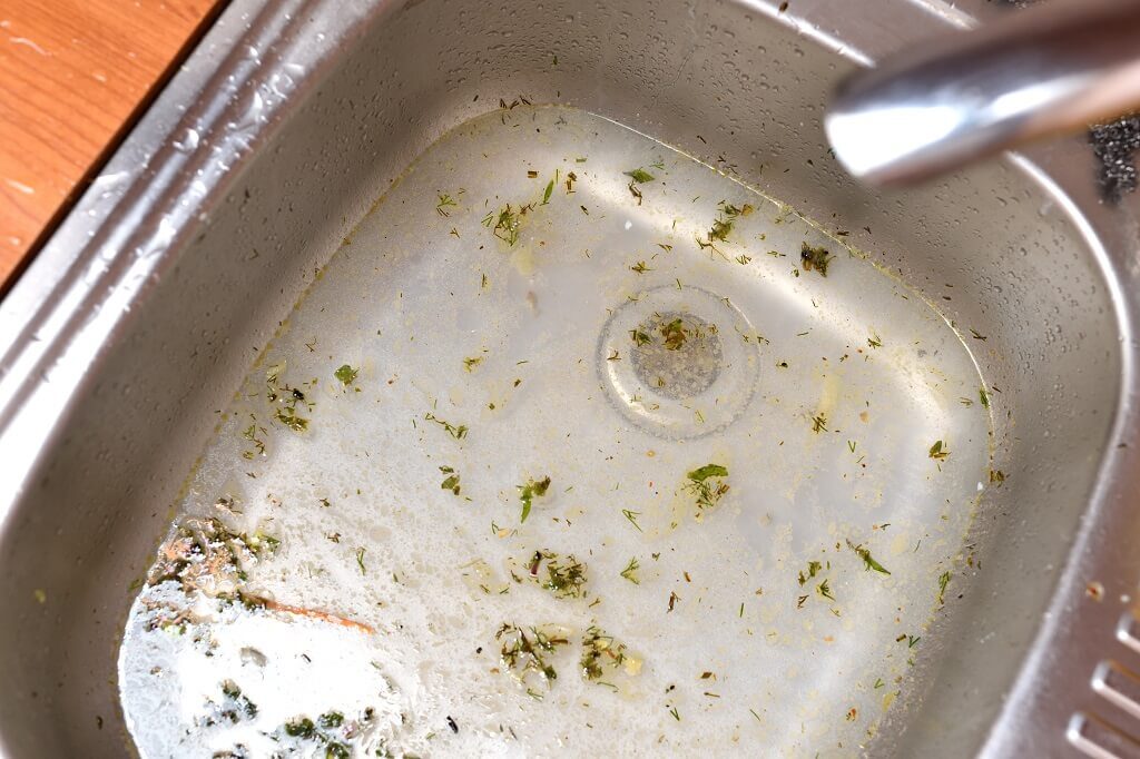 Slow draining kitchen sink with dirty water