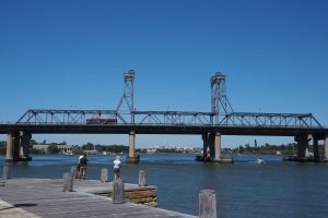 Industrial area next to river in Meadowbank. Industrial-looking bridge in midground. Gladesville Plumbing Services offers plumbing help in this North Sydney suburb.