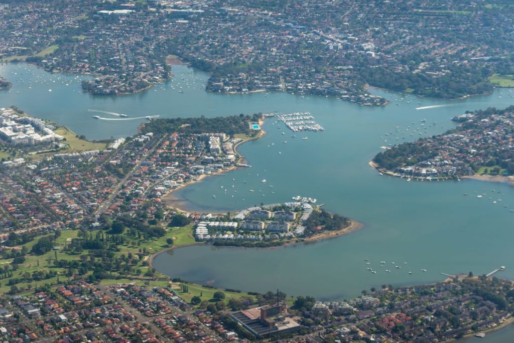 Drone image of Tennyson Point. Lots of rounded shorelines bordering the Paramatta river. Packed with a variety of houses, all serviceable by Gladesville Plumbing Services.