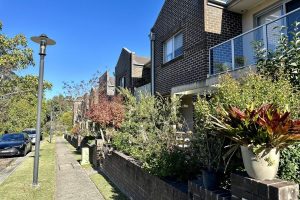 Street with brick townhouses and lots of greenery in Eastwood, North Sydney. Area serviced by Gladesville Plumbing Services.