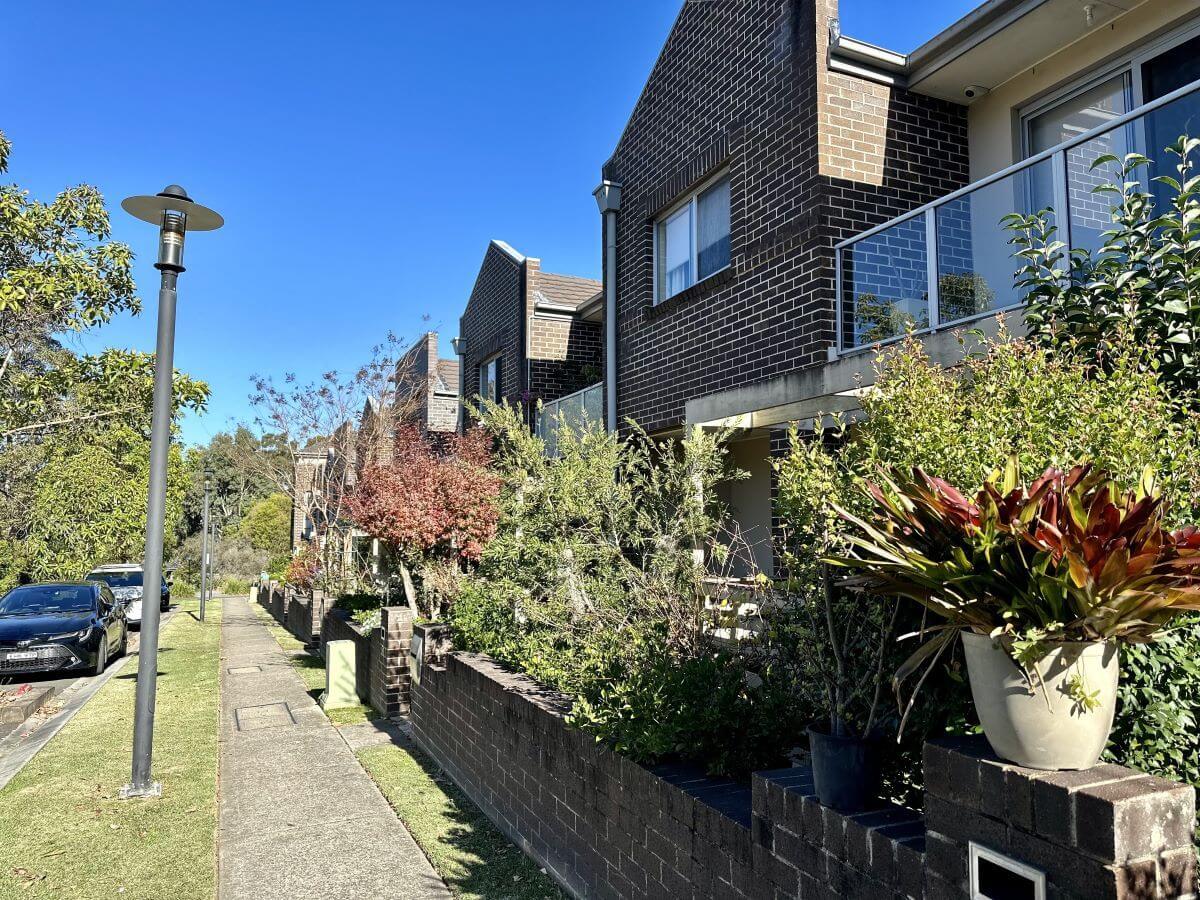 Street with brick townhouses and lots of greenery in Eastwood, North Sydney. Area serviced by Gladesville Plumbing Services.