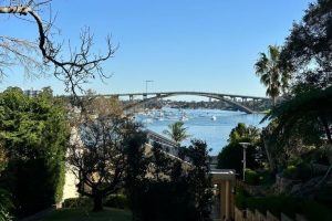 Steps down to home in Hunters Hill with bridge and river behind. Surrounded by trees. Suburb in North Sydney service area for Gladesville Plumbing Services.