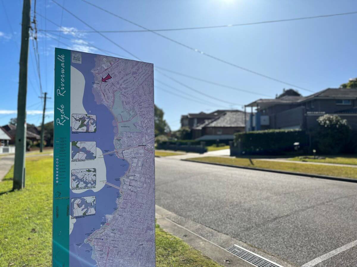 GPS_Suburbs_-_Melrose_Park Street in Melrose Park featuring sign of riverwalk map. Simple suburban house in background. Gladesville Plumbing Services emergency service area.