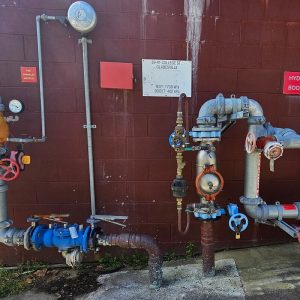 Backflow prevention system, dials and pipes coloured in red, blue and white. Backflow prevention devices and backflow testing by reliable plumbers in North Sydney.