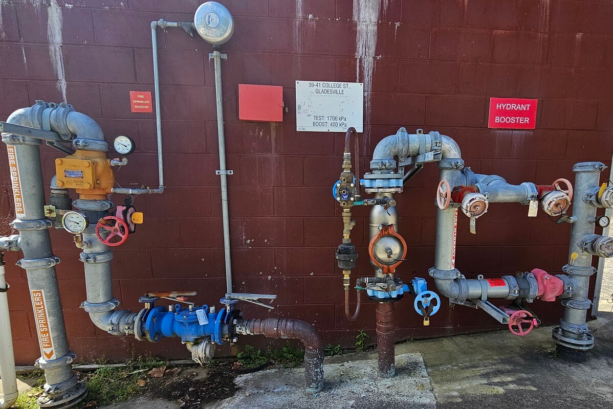Backflow prevention system, dials and pipes coloured in red, blue and white. Backflow prevention devices and backflow testing by reliable plumbers in North Sydney.