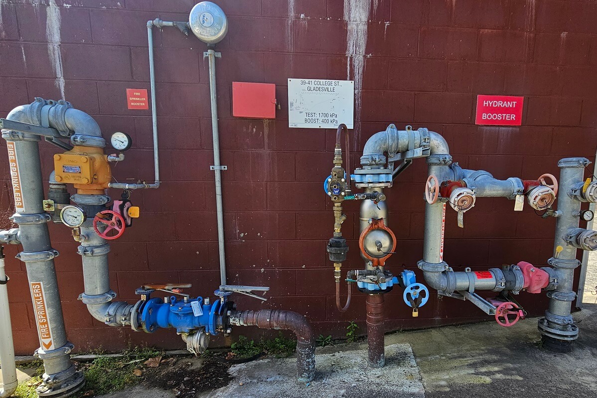 GPS Backflow Prevention Backflow prevention system, dials and pipes coloured in red, blue and white. Backflow prevention devices and backflow testing by reliable plumbers in North Sydney.