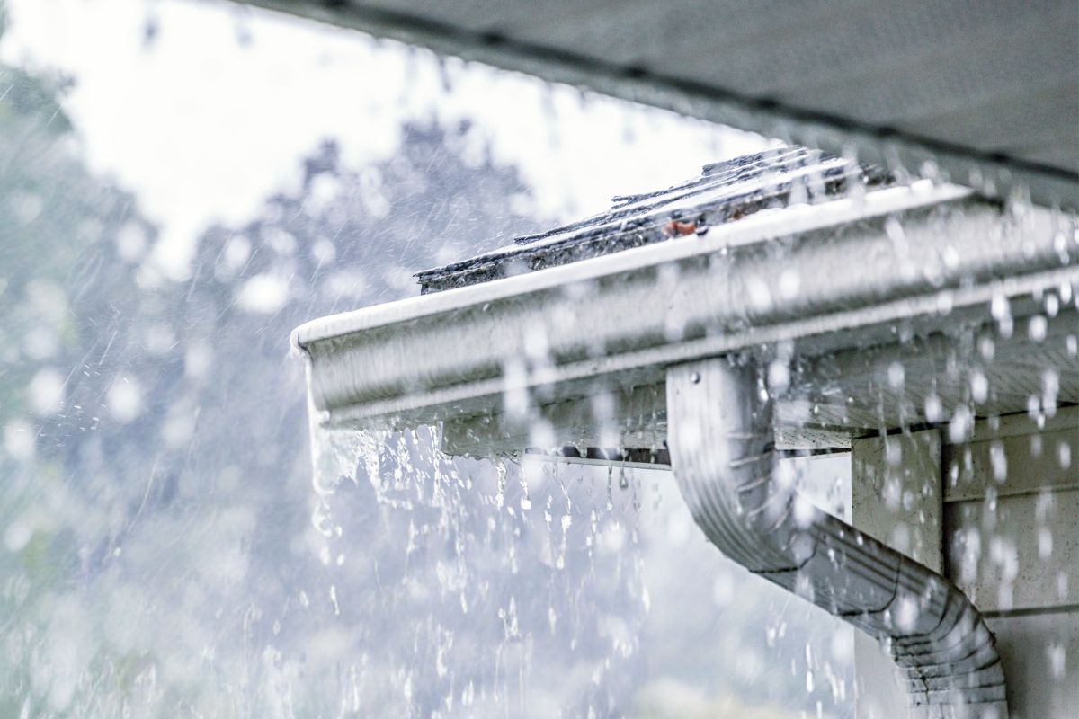 Gutters overflowing as heavy rain overwhelms roof drainage system